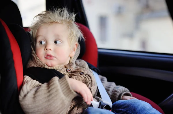 Portret van mooie peuter jongen in de autostoel zitten — Stockfoto