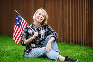 Amerikan bayrağı tutan mutlu genç kadın