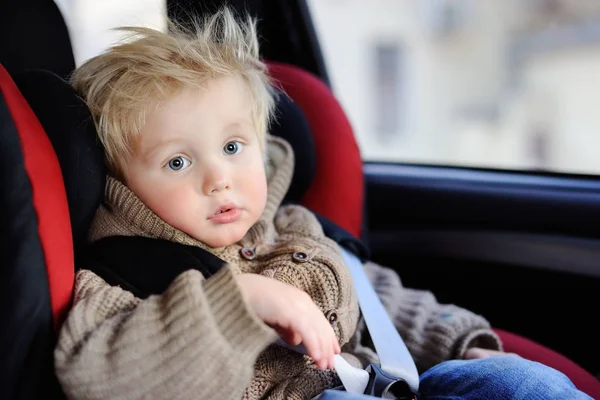 Portrait of pretty toddler boy sitting in car seat — Stock Photo, Image