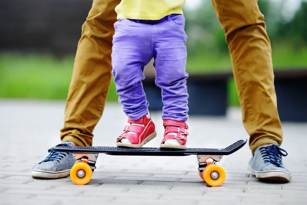 Κορίτσι μικρό παιδί που μαθαίνει να skateboard με τον πατέρα της, κοντινό πλάνο — Φωτογραφία Αρχείου