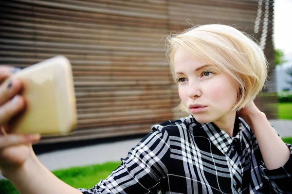 Jonge vrouw maken een selfie buitenshuis — Stockfoto