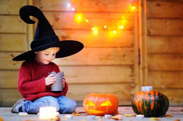 Little wizard looking on candle. Halloween concept