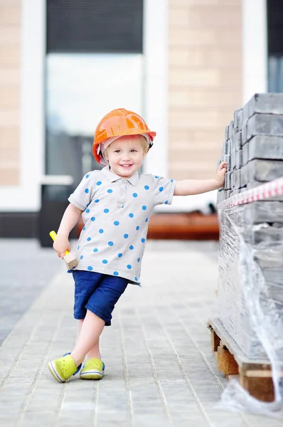 Portrait of little builder in hardhat with hammer working outdoors — Stok Foto