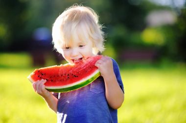 Küçük çocuk açık havada taze karpuz yeme