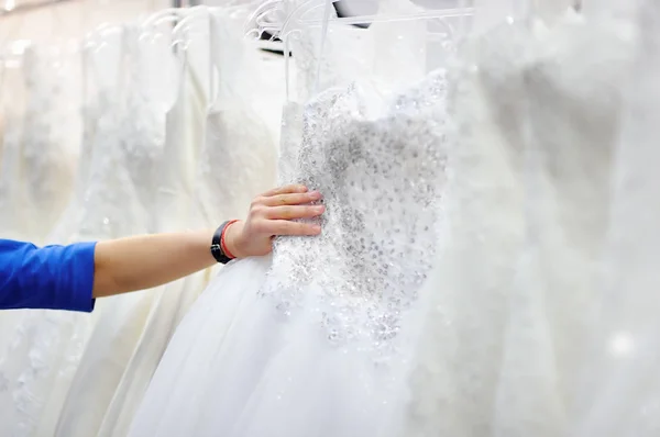 Jovem mulher escolhendo o vestido de noiva perfeito durante as compras de noiva — Fotografia de Stock