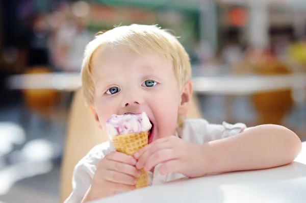 Roztomilý malý chlapec jíst zmrzlinu gelato v interiéru kavárny — Stock fotografie