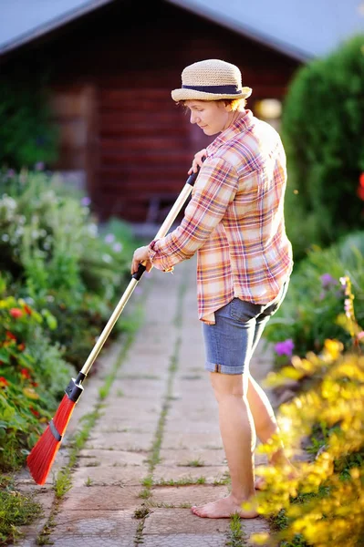 국내 정원에서 보도 청소 하는 여자 — 스톡 사진