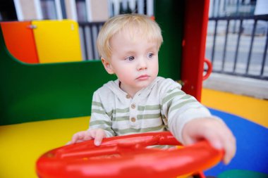 Oyun parkında eğleniyor şirin yürümeye başlayan çocuk