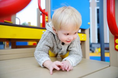 Oyun parkında eğleniyor şirin yürümeye başlayan çocuk
