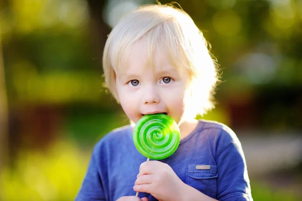 Menino bonito da criança com grande pirulito verde — Fotografia de Stock