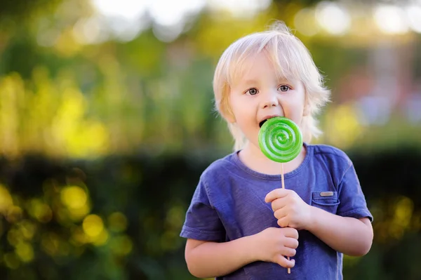 Lindo niño con gran piruleta verde — Foto de Stock