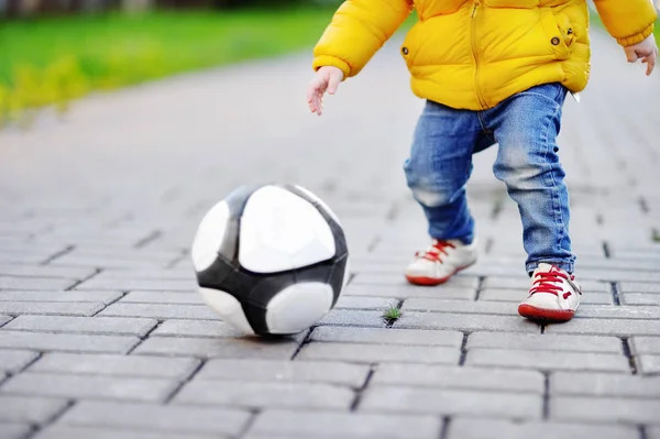 Menino se divertindo jogando um jogo de futebol no dia ensolarado de primavera ou outono — Fotografia de Stock