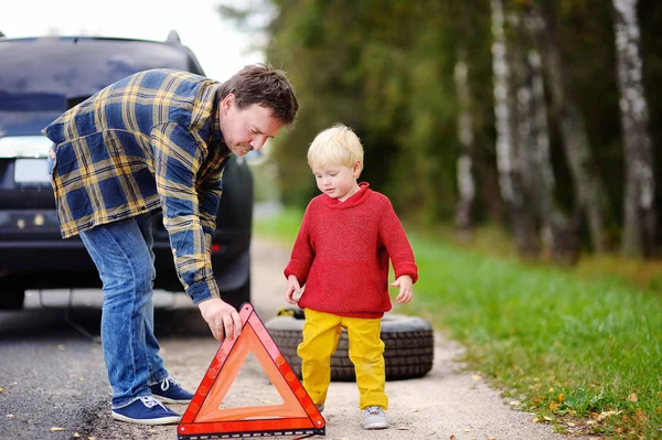 Far och hans lille son reparera bilen och byta hjul tillsammans sommardag — Stockfoto