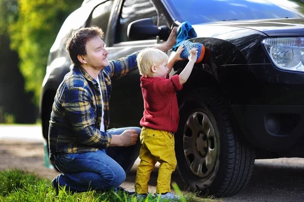 Středním věku otce se synem batole mytí auta spolu venku — Stock fotografie