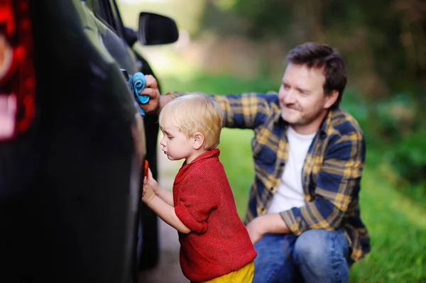 Medelåldern far med sonen småbarn tvätta bilen tillsammans utomhus — Stockfoto