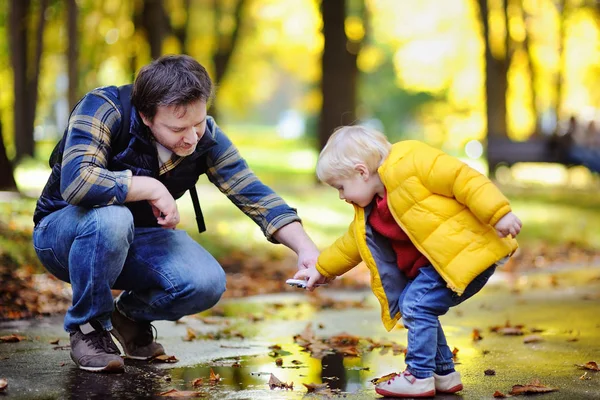 Père d'âge moyen jouant avec son fils tout-petit ensemble dans un parc d'automne — Photo