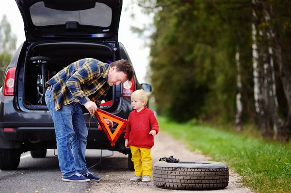 Far och hans lille son reparera bilen och byta hjul tillsammans sommardag — Stockfoto