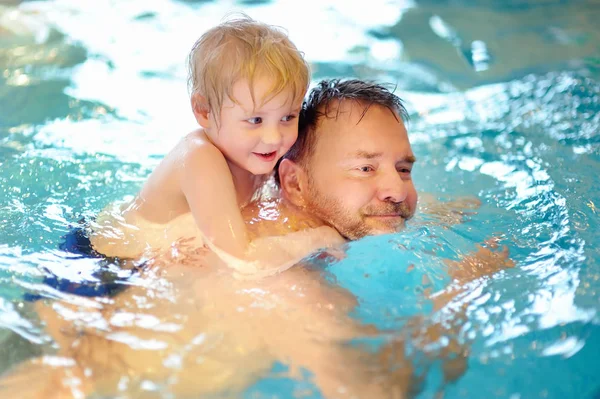 Szczęśliwy uśmiechający się mały chłopiec z ojcem w basenie — Zdjęcie stockowe