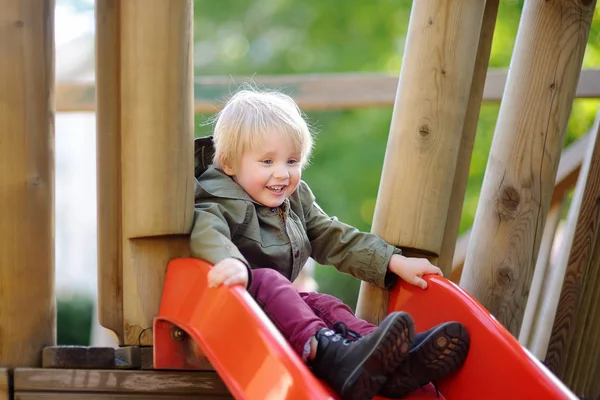 Felice ragazzino divertirsi sul parco giochi all'aperto — Foto Stock