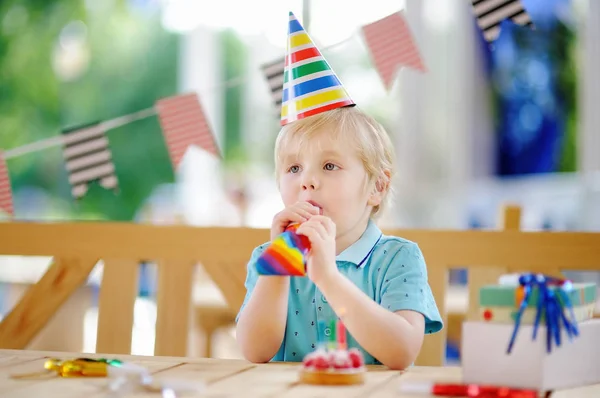 かわいい男の子は、カラフルな装飾とケーキで誕生日パーティーを祝う — ストック写真