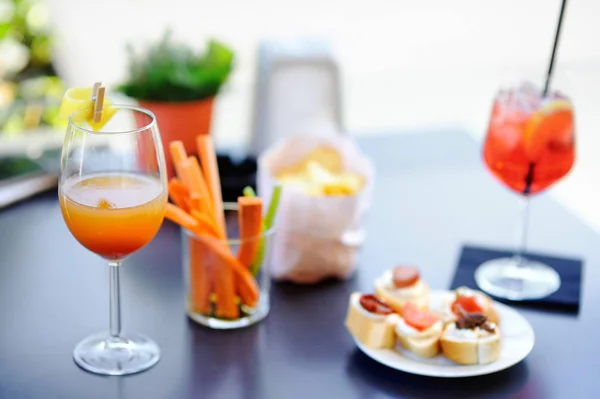 Aperitivos italianos / aperitivo: dois copos de coquetel e prato de aperitivo na mesa — Fotografia de Stock