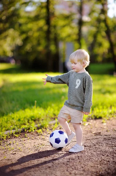 Menino se divertindo jogando um jogo de futebol no dia ensolarado de verão — Fotografia de Stock