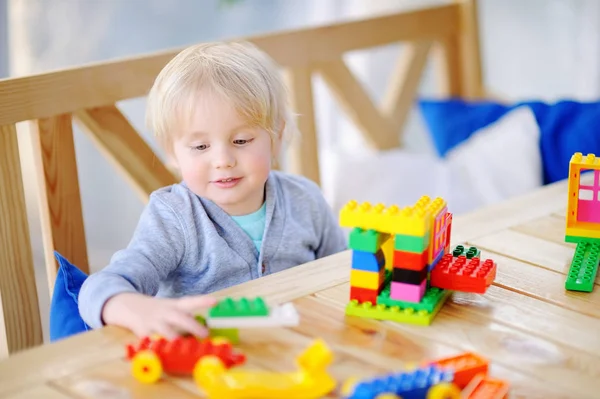 Niño jugando con bloques de plástico de colores en el jardín de infantes o en casa —  Fotos de Stock