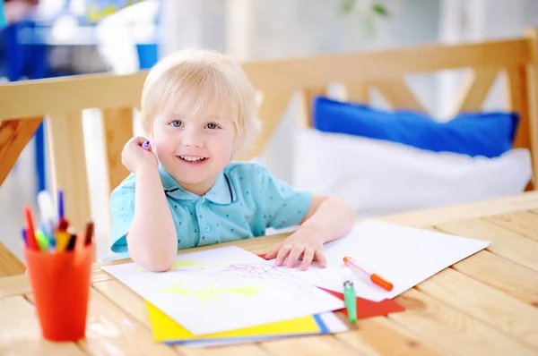 Lindo niño pequeño dibujo y pintura con marcadores de colores en el jardín de infantes —  Fotos de Stock
