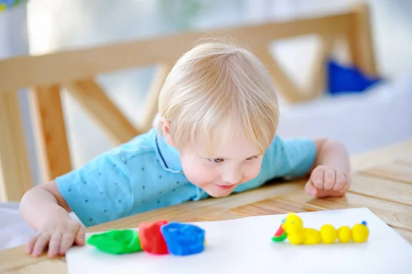 Menino criativo brincando com argila de modelagem colorida no jardim de infância — Fotografia de Stock