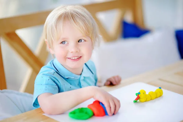 Creatieve jongen spelen met kleurrijke modellering clay op kleuterschool — Stockfoto