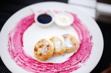 Lezzetli cheesecakes/syrniki beyaz plaka üzerinde