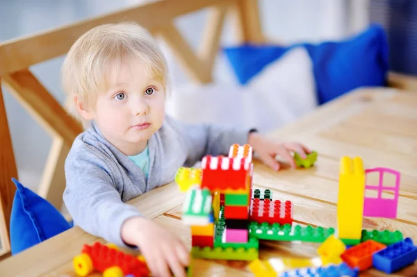 किंडरगार्डनमध्ये रंगीत प्लास्टिक ब्लॉक खेळत लहान मुलगा . — स्टॉक फोटो, इमेज