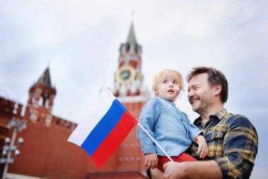 Orta yaş erkek ve onun küçük oğlu ile arka plan üzerinde işçinin Kulesi (Rusya, Moskova) Rus bayrağı