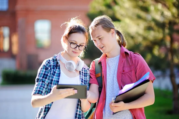 Giovani studenti felici con libri e appunti nel campus universitario — Foto Stock