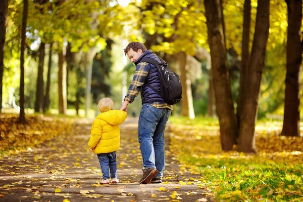 Padre e suo figlio minore passeggiano nella foresta autunnale — Foto Stock