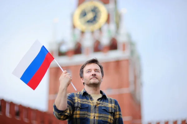 Мужчина средних лет с российским флагом на фоне Спасской башни (Россия, Москва) — стоковое фото