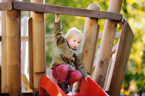 Felice ragazzino divertirsi sul parco giochi all'aperto — Foto Stock