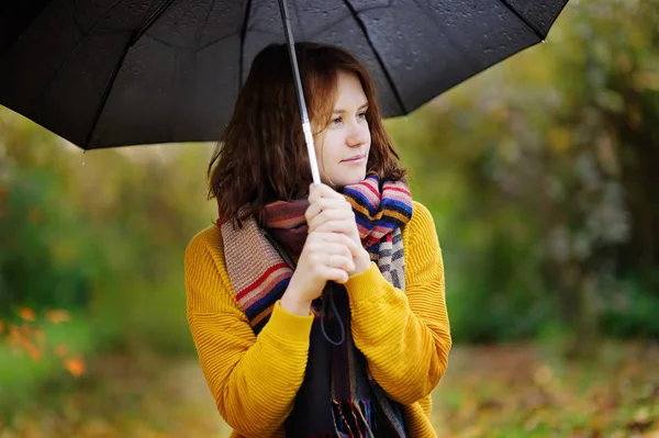 Jolie jeune femme marchant à temps pluvieux d'automne nuageux — Photo
