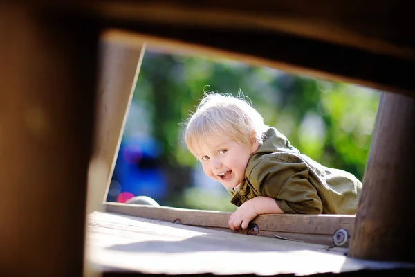 Joyeux petit garçon qui s'amuse sur une aire de jeux extérieure — Photo