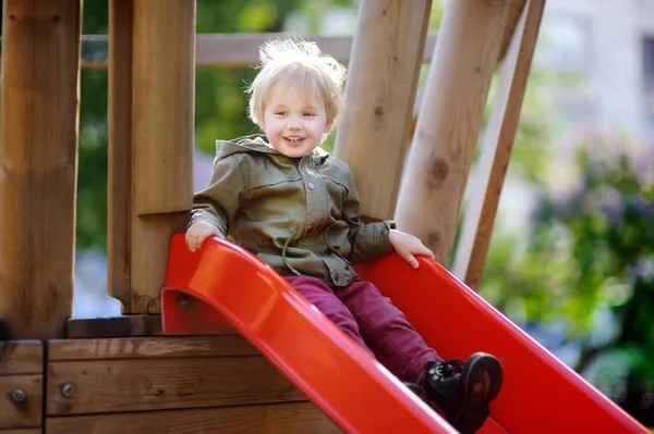 Joyeux petit garçon qui s'amuse sur une aire de jeux extérieure — Photo