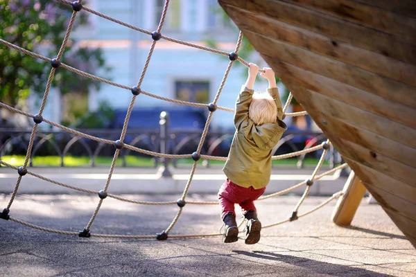 Joyeux petit garçon qui s'amuse sur une aire de jeux extérieure — Photo