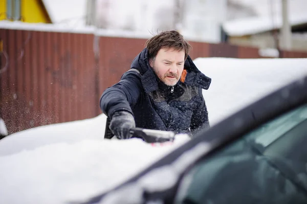 雪から彼の車を洗浄するためツールを使用している人 — ストック写真