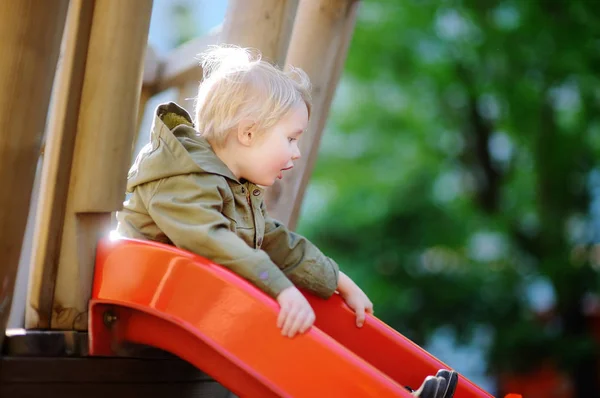 Счастливый маленький мальчик веселится на открытой площадке — стоковое фото