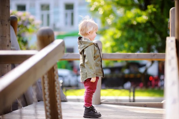 Menino feliz se divertindo no playground ao ar livre — Fotografia de Stock