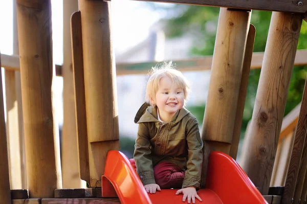 Joyeux petit garçon qui s'amuse sur une aire de jeux extérieure — Photo