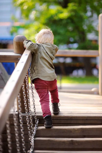 Joyeux petit garçon qui s'amuse sur une aire de jeux extérieure — Photo