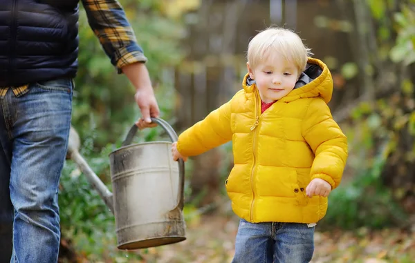 可爱的蹒跚学步的男孩帮助父亲给植物浇水 — 图库照片