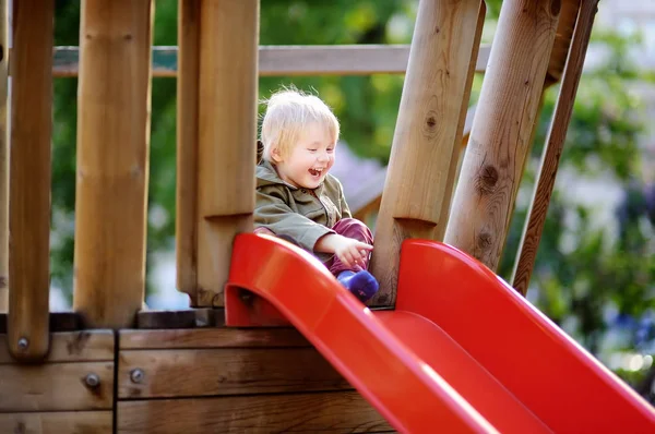 Joyeux petit garçon qui s'amuse sur une aire de jeux extérieure — Photo