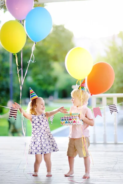 Niño y niña se divierten y celebran fiesta de cumpleaños con globos de colores — Foto de Stock