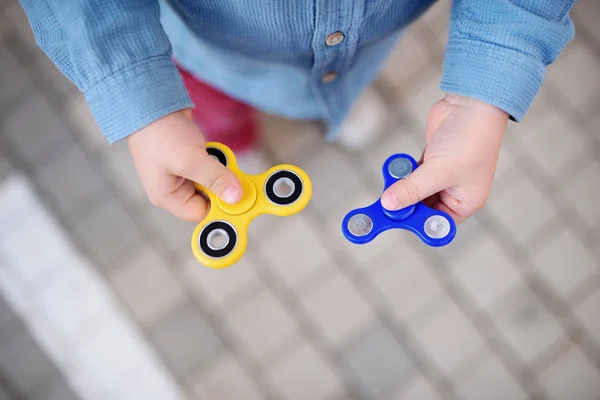 Close-up photo przedszkolak chłopca gospodarstwa Błystki obrotowe fidget — Zdjęcie stockowe